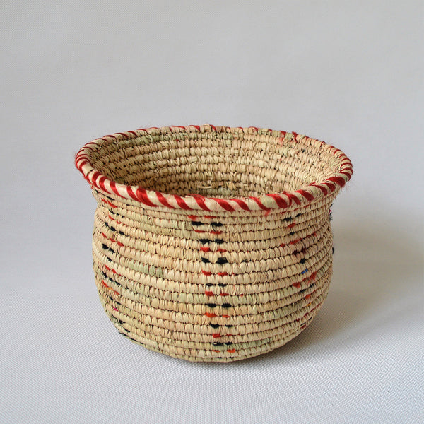 Wide woven bowl decorated with red and black fabric