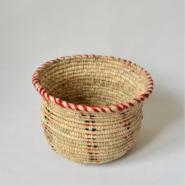 Wide woven bowl decorated with red and black fabric