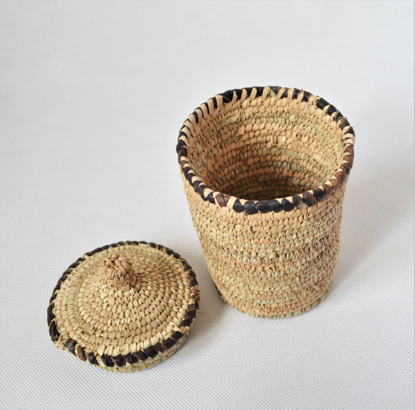 Long woven container lidded with true leather decoration